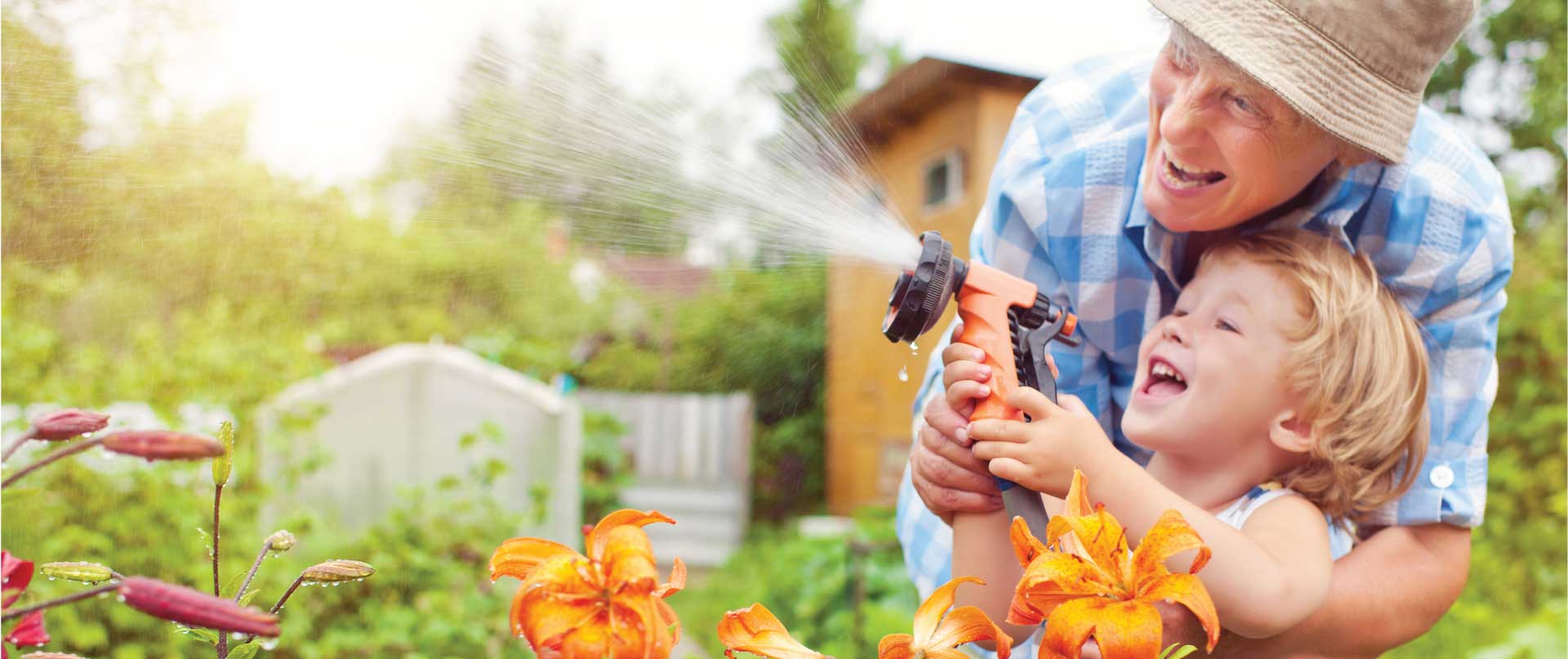 grandma and grandson watering flowers