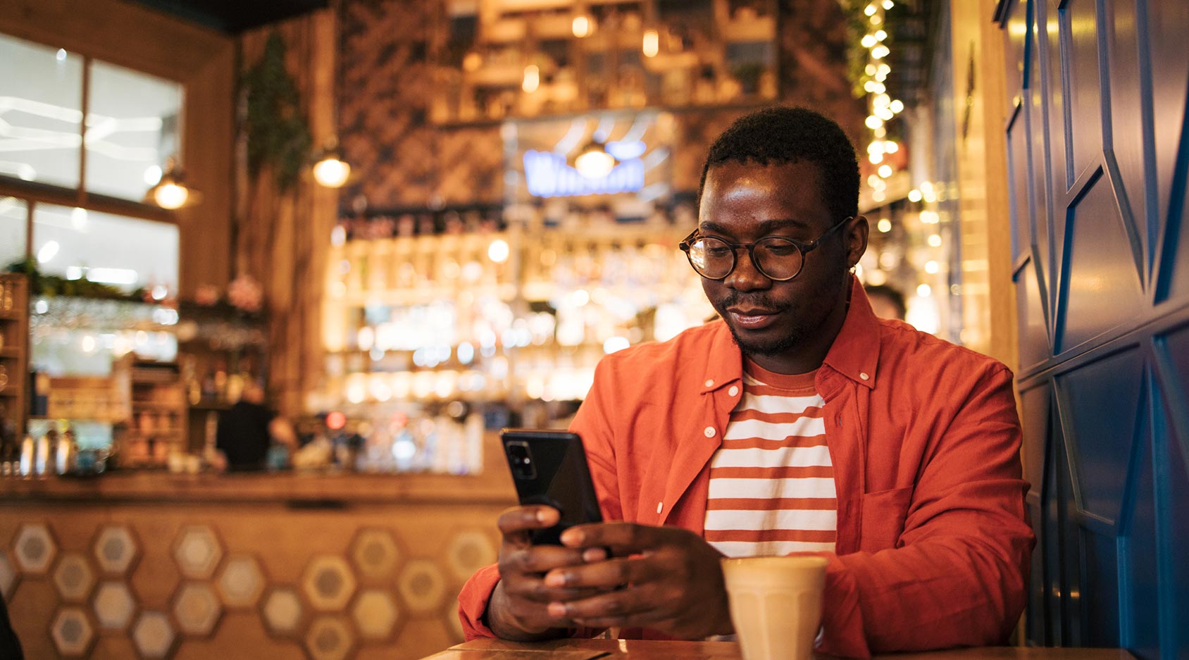 Man using phone in coffee shop