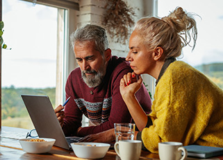 Mature couple going over finances in kitchen