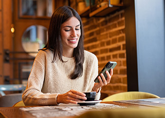 Woman using phone in coffee shop