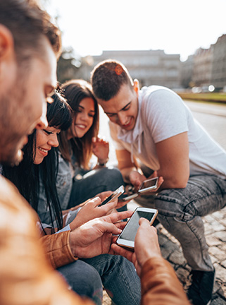 Group of friends looking at phone outside