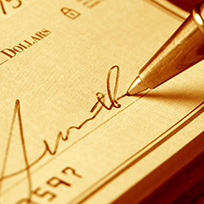 Close up of person writing a check
