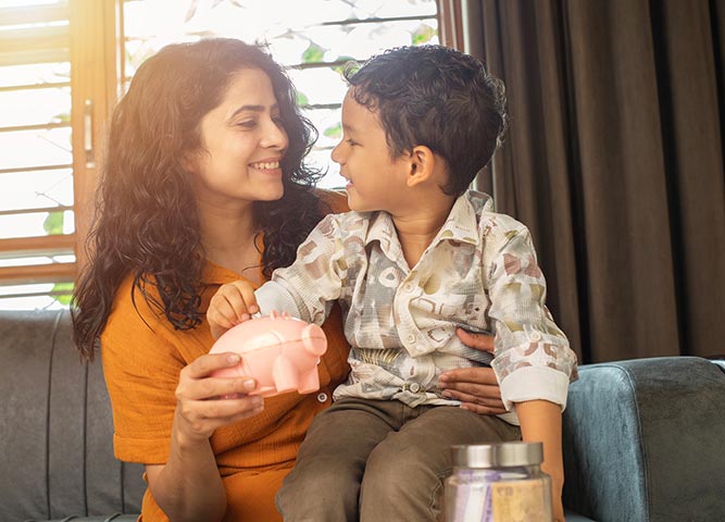 Woman and son putting coins in piggy bank