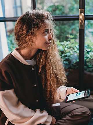 Young woman using phone in lobby