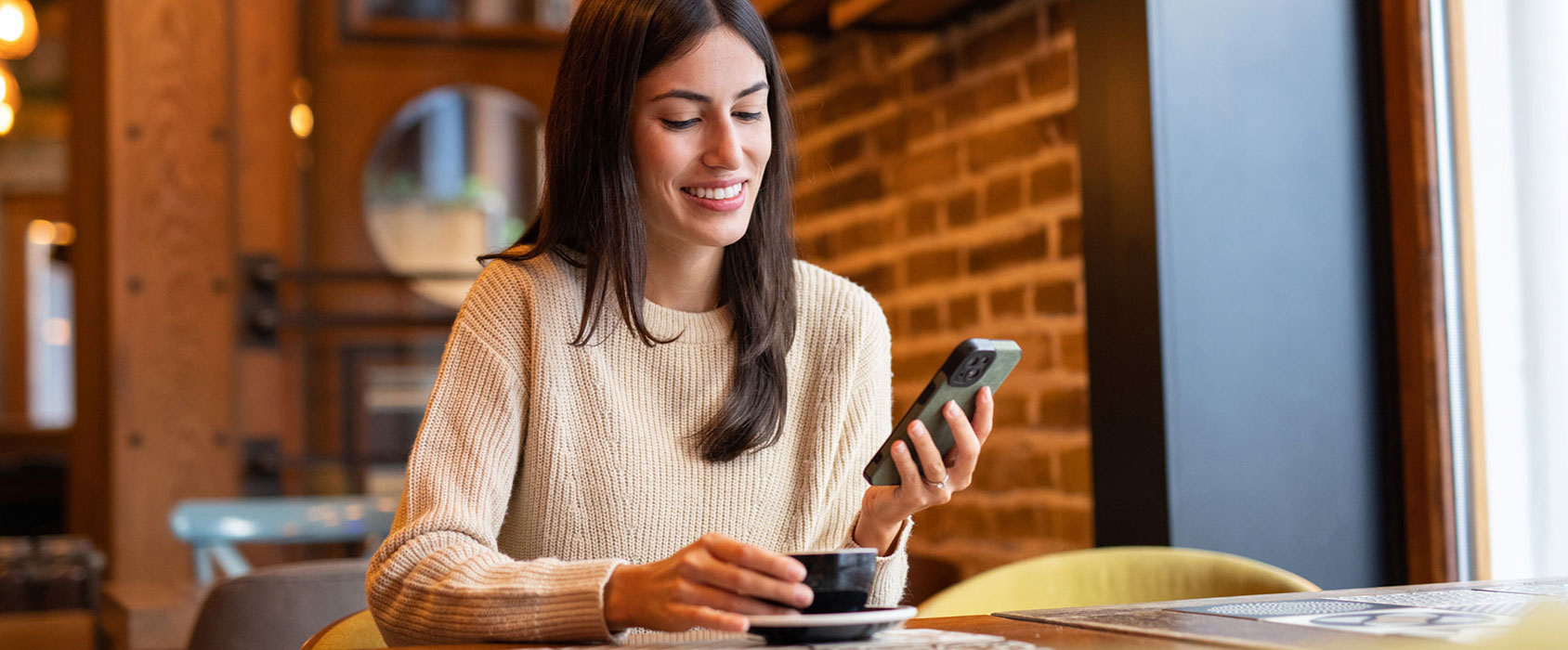 Woman using phone in coffee shop